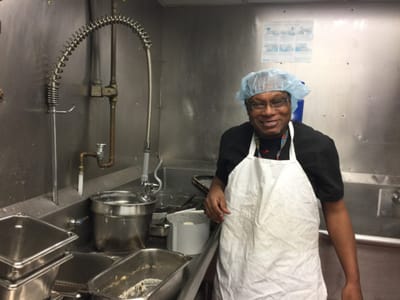 Staff member smiling in a kitchen setting
