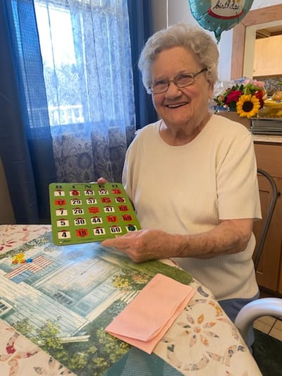 Resident playing bingo with a smile in an activity room