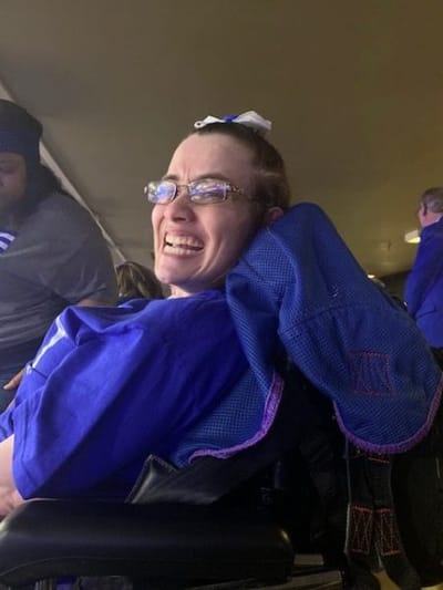 Resident smiling in a wheelchair at an event