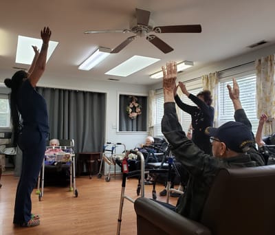 Residents participating in a seated exercise class