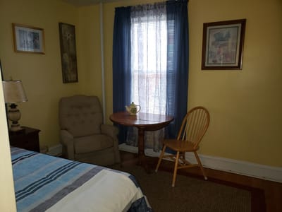 Cozy resident room with armchair and table
