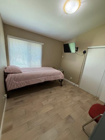 A simple resident room with a bed and TV