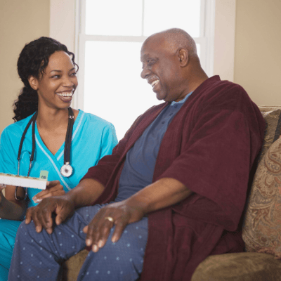Nurse and resident laughing together in a cozy setting