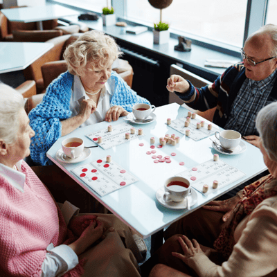 Residents playing bingo in a bright activity room