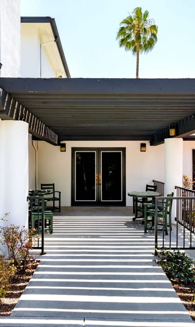 Entrance area with patio seating and palm tree
