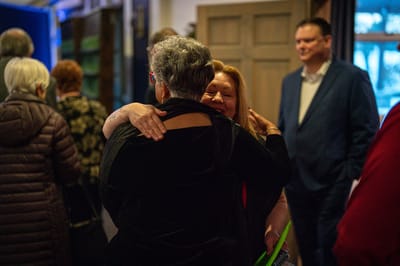 Residents embracing in a warm indoor setting