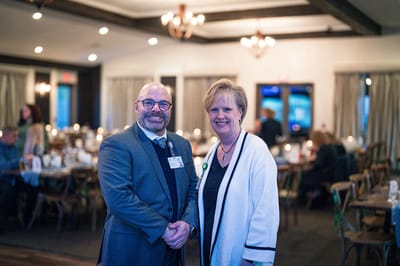 Two staff members smiling in a communal dining area
