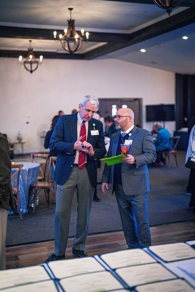 Two men talking at a social event indoors