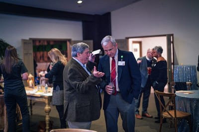 Two men talking in a social gathering at the facility
