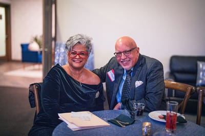 Two people posing together at a social event