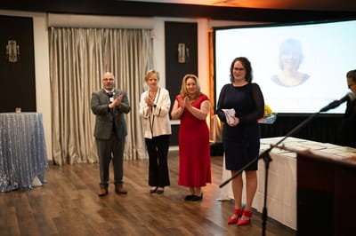 Four people celebrating an event at a facility.