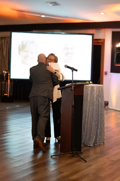 Two people hugging during an event in a decorated room