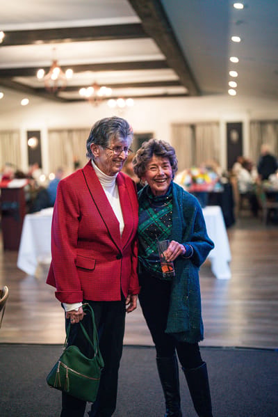 Two residents smiling together in a lively common area