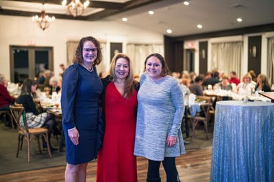 Three staff members posing together at an event