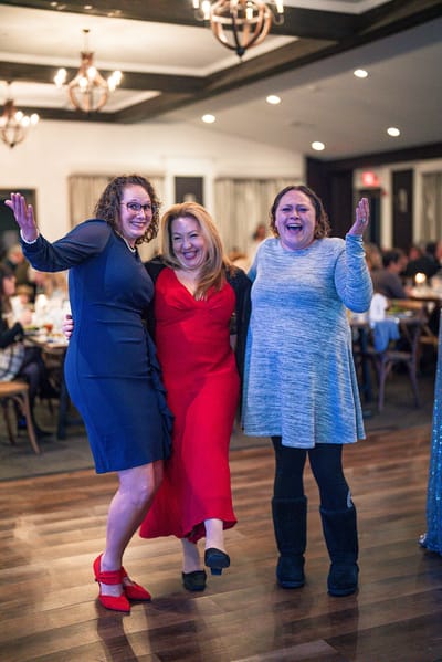 Three women celebrating at a festive event
