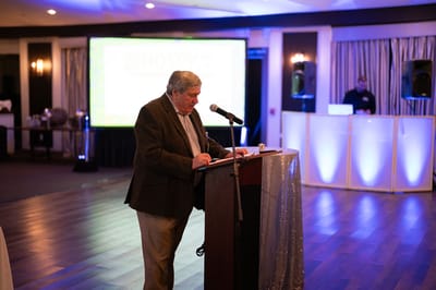 A speaker addressing attendees at a hospice event