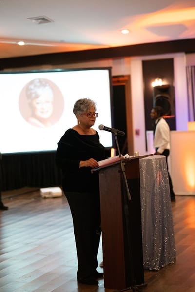 A woman speaking at an event in an interior space