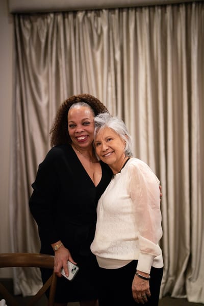 Two residents smiling together in an interior setting