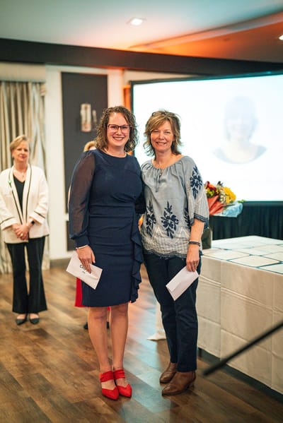 Two staff members smiling during an event
