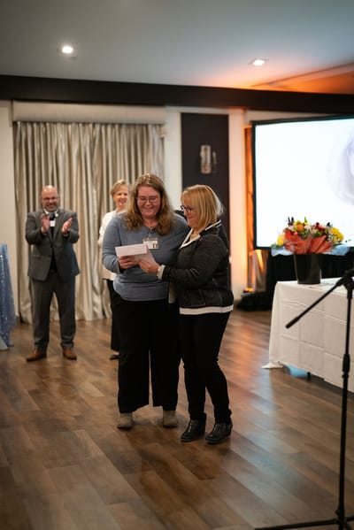 Two staff members celebrating an achievement during an event