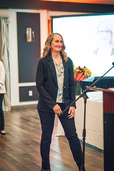 A staff member speaking at an event in a facility interior