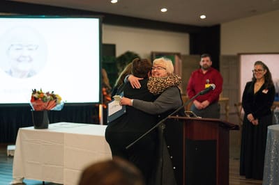 Two women embracing in a celebration event