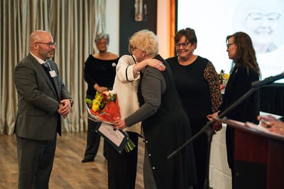 Celebration event with staff members and a honoree