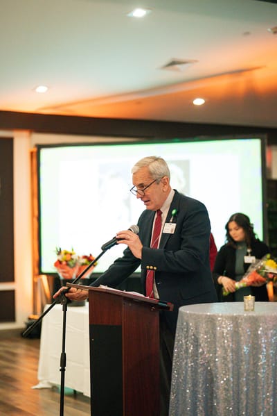 A man speaking at a microphone during an event