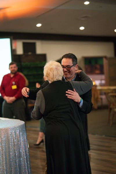 A staff member embracing a resident during an event