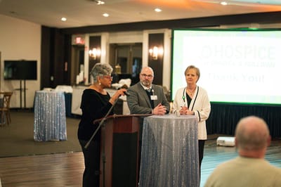 Staff members at a celebration event giving a speech