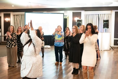 Group of women clapping and dancing at an event