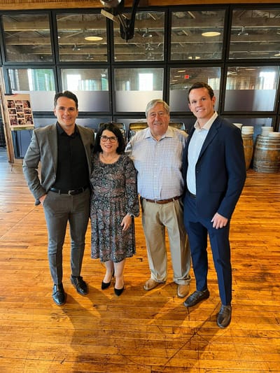 Group of four people posed in an interior event space