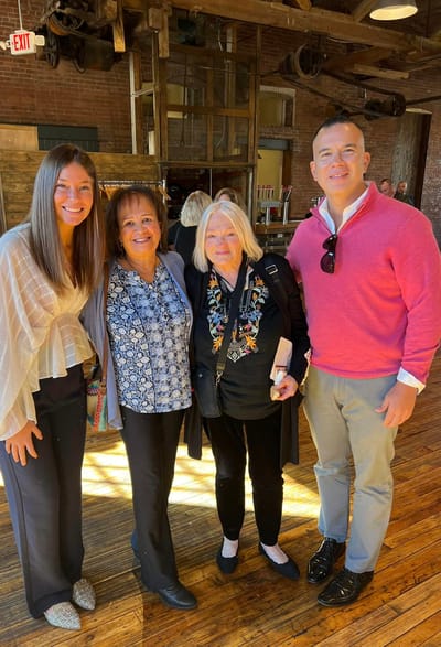 Four people posing for a photo in a social setting