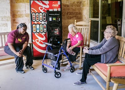 Residents and staff chatting in an outdoor common area