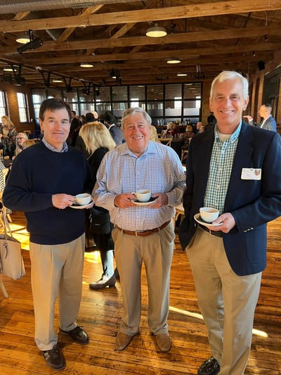 Three men enjoying coffee in a social gathering setting.