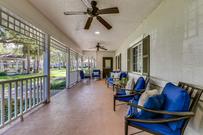 Outdoor seating area with blue chairs and fans
