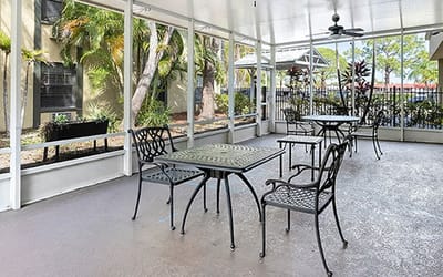 Outdoor seating area with tables surrounded by greenery
