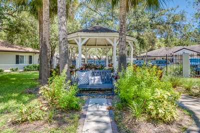 Outdoor seating area with gazebo and lush greenery