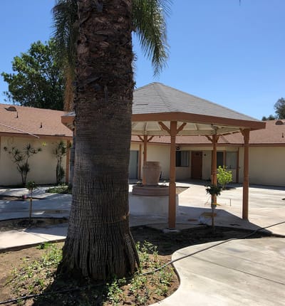 Outdoor gazebo surrounded by landscaping in a senior living facility