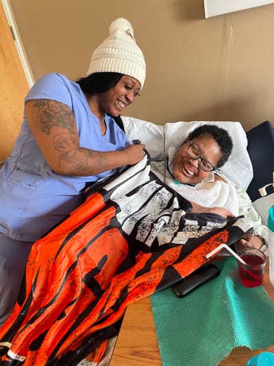 Caregiver assisting a resident with a blanket
