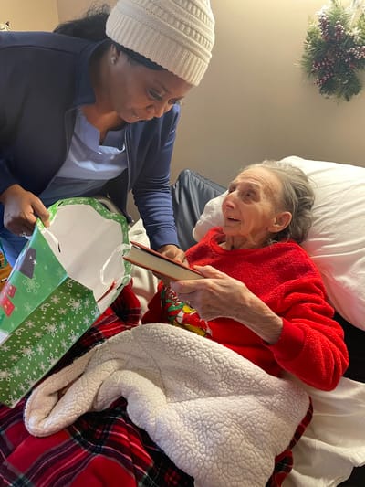 A staff member and resident exchanging gifts