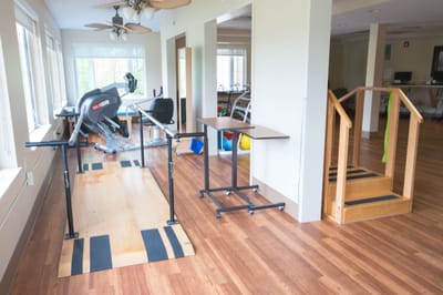 Rehabilitation gym area with equipment and wooden ramp