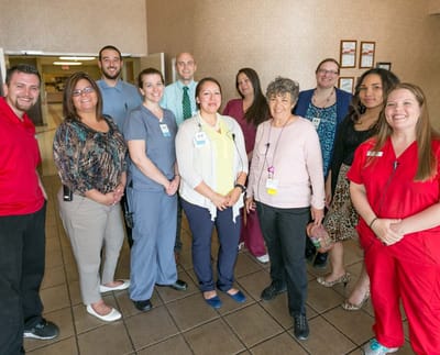Staff members posing together in a common area