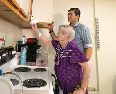 Senior resident and staff member in a kitchen setting