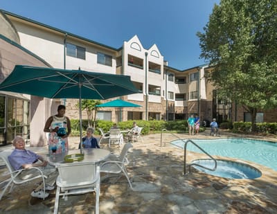 Residents enjoying the outdoor pool area with staff assistance