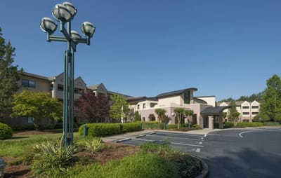 Exterior view of Delmar Gardens Senior Living entrance and landscaping