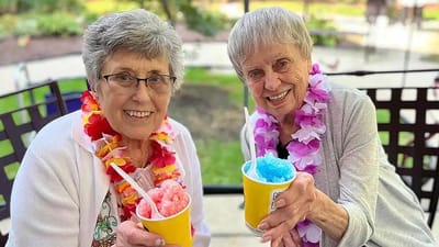 Two residents enjoying shaved ice outdoors at the facility