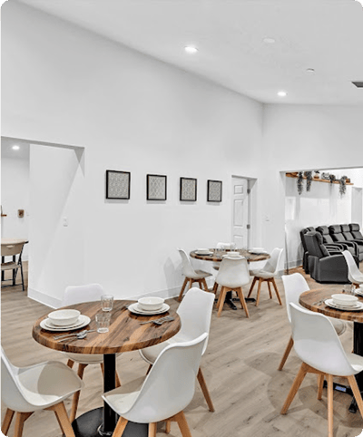 Dining area with wooden tables and white chairs
