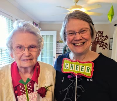Residents smiling with 'Cheer' signs during an event