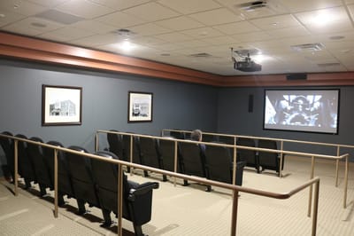 Cozy movie theater room with viewing screen and chairs